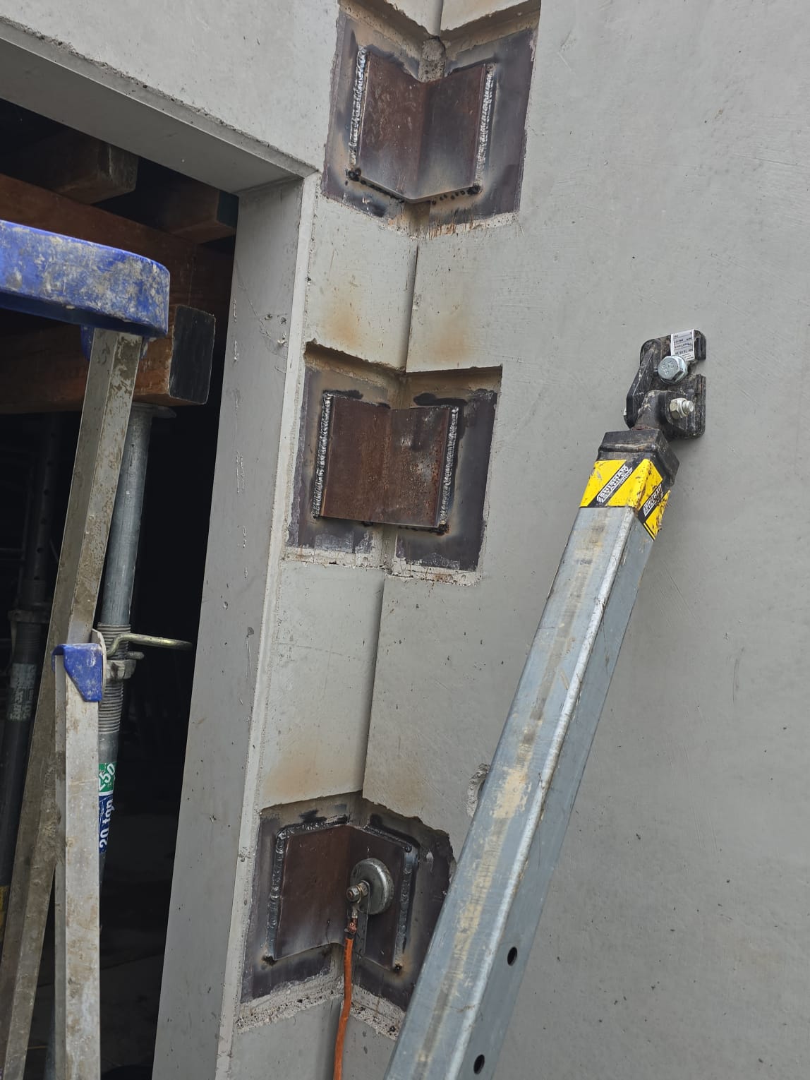 Welded steel brackets on a concrete column