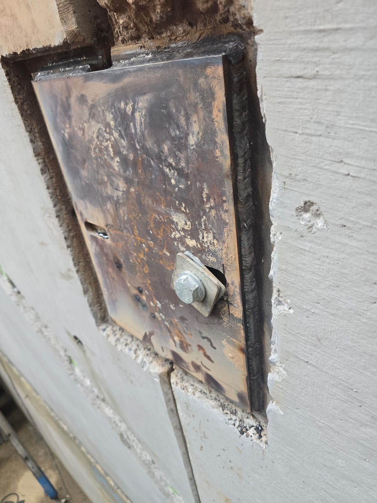 Structural steel plate welded to concrete