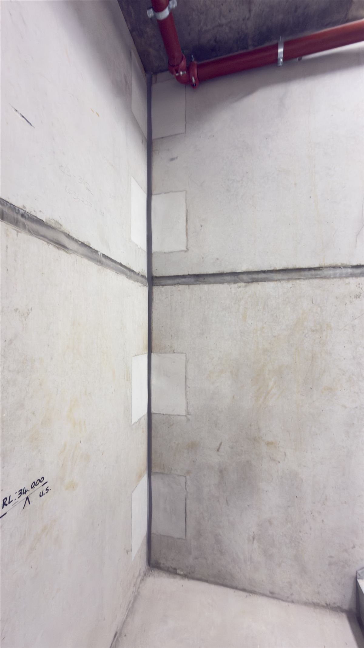 Caulked vertical corner joint with patched penetrations on precast walls
