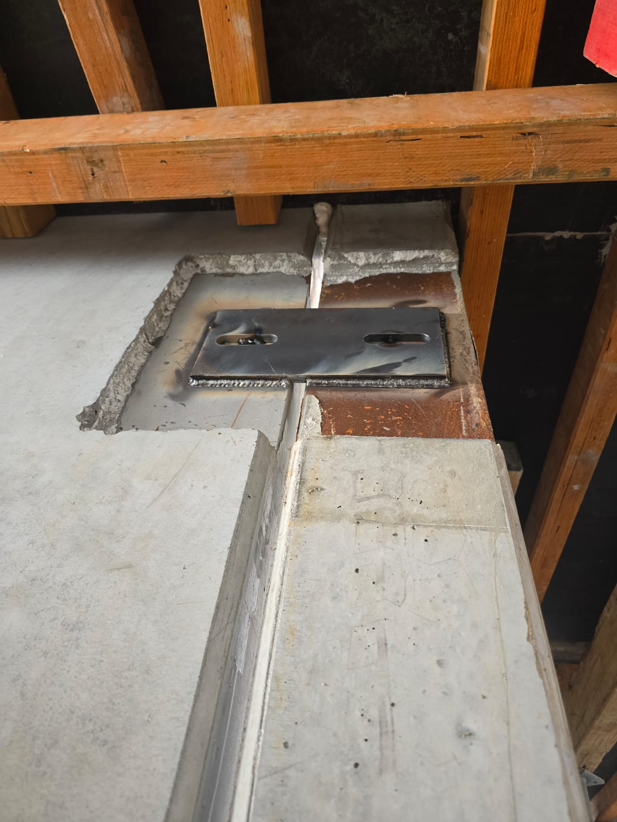 Welded steel connection plate in flooring